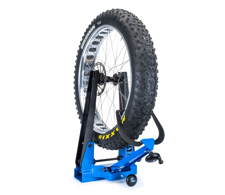 „Park Tool TS-4.3“, laikantis plačių padangų dviračio ratą su padanga
